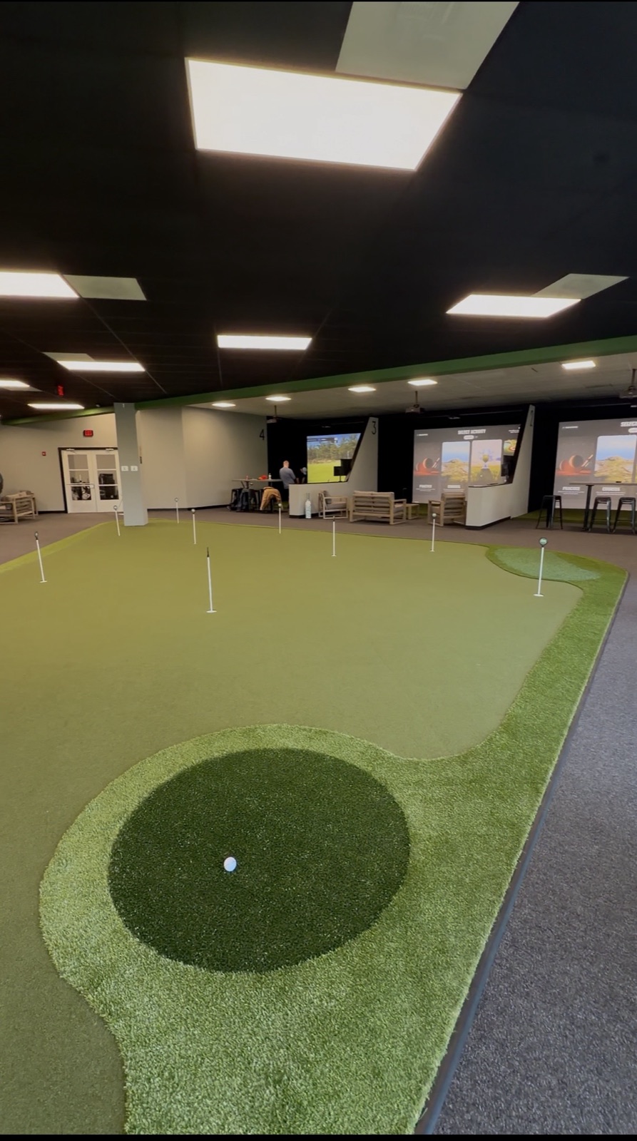 Putting green and simulator bays inside Rain Check Golf